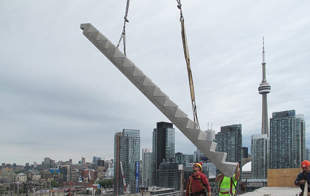 Precast Concrete Stairs Being Crane Lifted In Front Of Toronto Skyline
